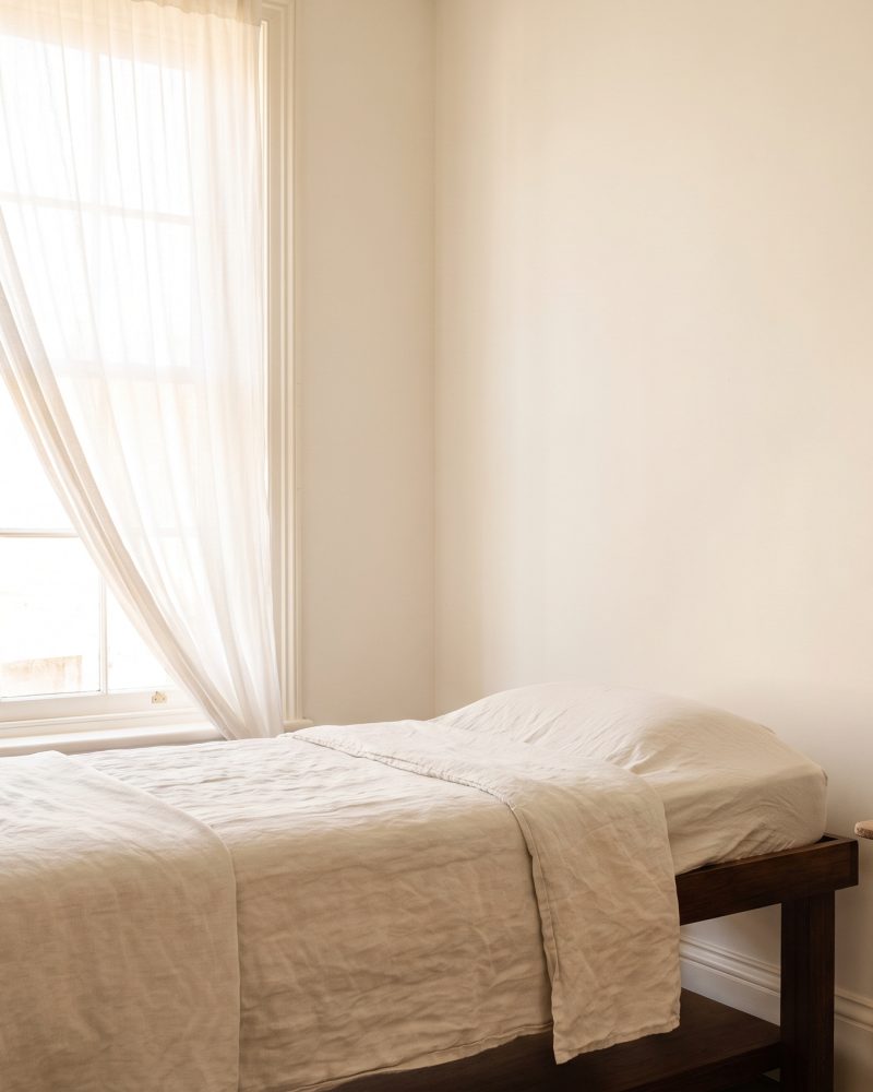 The London treatment room, daylight through a sash window onto a plain wall.
