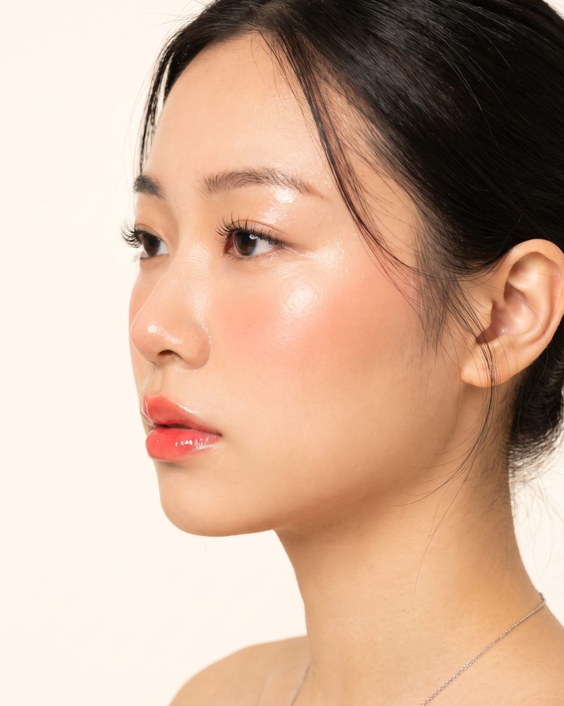 A three-quarter portrait with one hand at the jaw, showing a natural Builder Gel manicure.